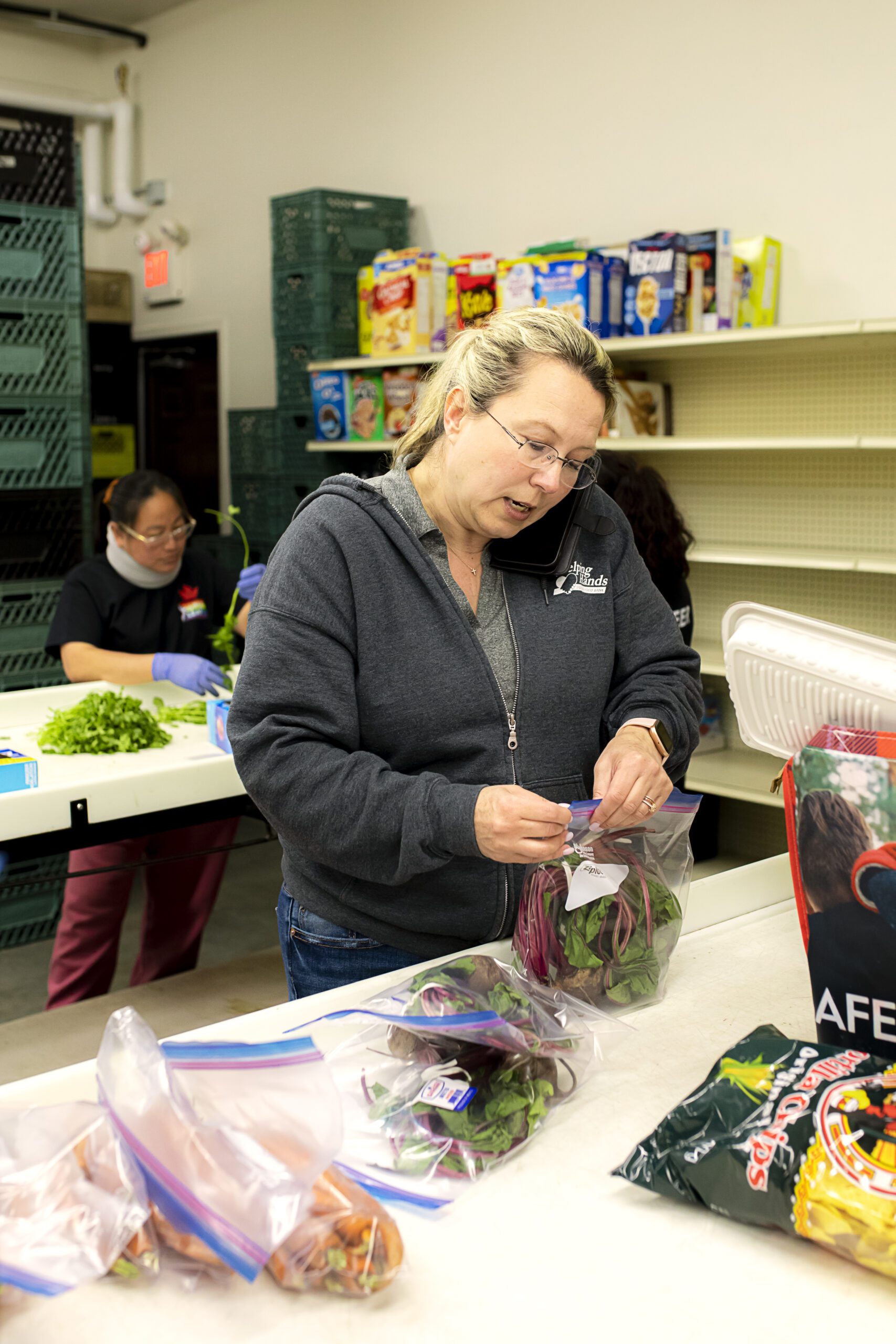 Group of unrecognizable volunteers working in community charity donation center, food bank and coronavirus concept.